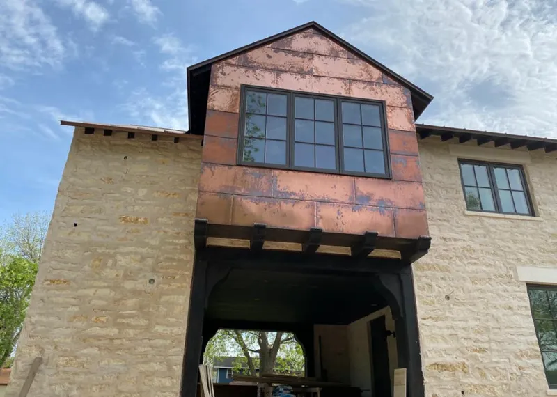 Copper metal panel facade on a stone building for Roof Repair in Raleigh